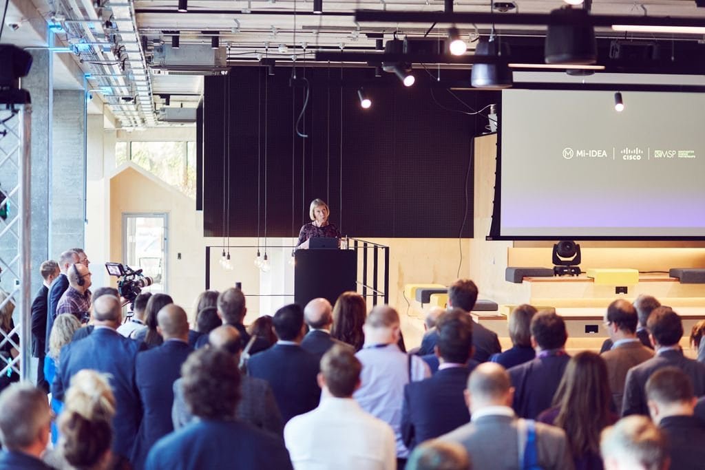 A speaker at a lectern addressing the audience at Health 2.0 Manchester